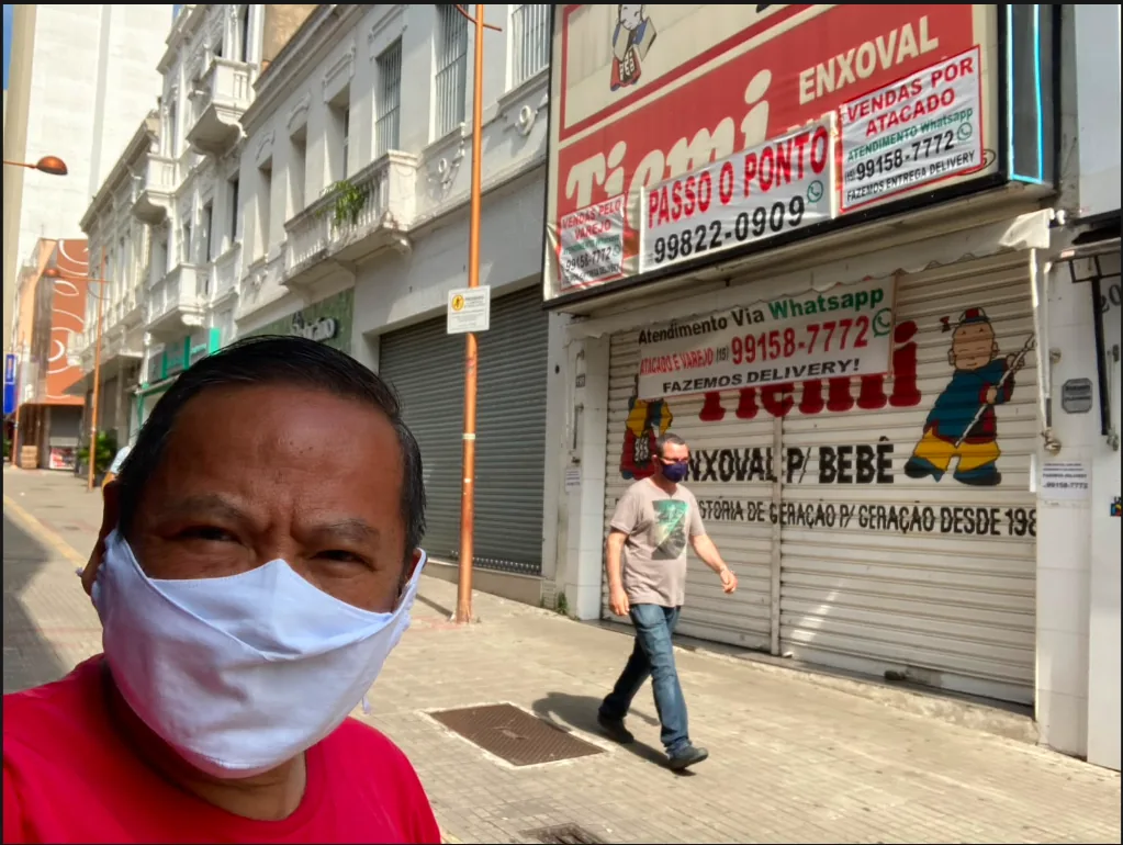 Fachada da Loja Tiemi durante a pandemia de 2020, com a porta de aço fechada e letreiros de atendimento via WhatsApp